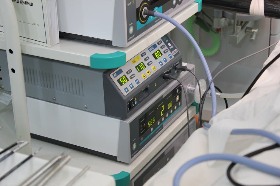 Close-up view of medical device with digital displays and cables in a hospital setting.